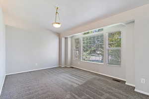 Unfurnished room featuring dark colored carpet