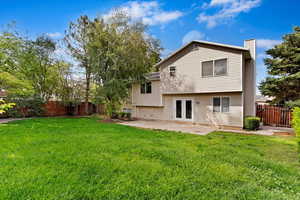 Back of property with french doors, a yard, and a patio