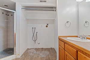 Bathroom featuring vanity, hardwood / wood-style floors, and an enclosed shower