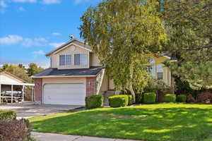 View of front of property with a garage and a front lawn