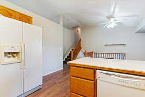 Kitchen with lofted ceiling, ceiling fan, hardwood / wood-style floors, and white appliances