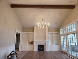 Unfurnished living room with a tile fireplace, hardwood / wood-style flooring, beamed ceiling, and a healthy amount of sunlight