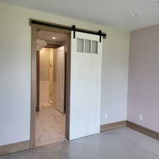 Unfurnished bedroom with a barn door and a textured ceiling