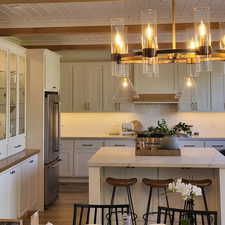 Kitchen featuring hanging light fixtures, high end fridge, light hardwood / wood-style flooring, a center island, and a breakfast bar