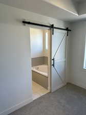 Bathroom featuring a textured ceiling, tile patterned floors, and a relaxing tiled tub