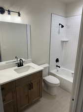 Full bathroom with tile patterned flooring, tiled shower / bath combo, vanity, and toilet