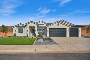 View of front of property featuring a garage and a front lawn