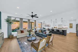 Living room with light hardwood / wood-style floors, sink, and ceiling fan