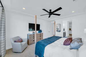 Carpeted bedroom featuring a tray ceiling and ceiling fan