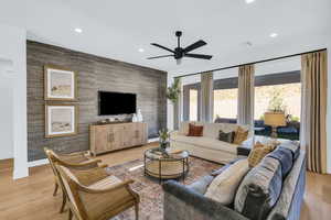 Living room with light hardwood / wood-style floors and ceiling fan