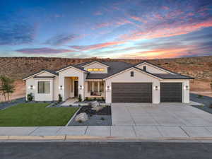 View of front of property with a garage and a yard