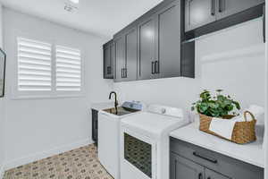 Washroom with cabinets, sink, and independent washer and dryer