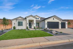 View of front of property with a garage and a front yard