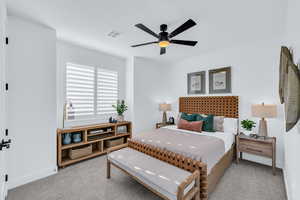 Carpeted bedroom featuring ceiling fan