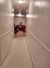 Hall with a textured ceiling and ornamental molding