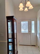 Foyer with an inviting chandelier and light tile patterned flooring