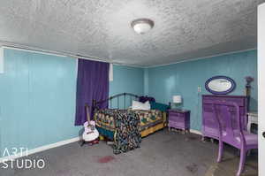 Bedroom with a textured ceiling and carpet flooring