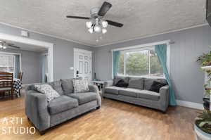 Living room with a textured ceiling, ceiling fan, and hardwood / wood-style flooring