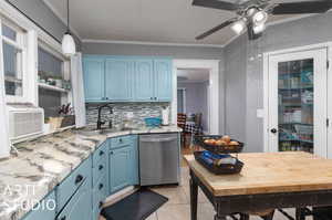 Kitchen featuring ceiling fan, blue cabinets, decorative light fixtures, dishwasher, and crown molding