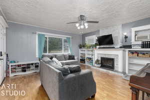 Living room featuring a textured ceiling, ceiling fan, and hardwood / wood-style flooring