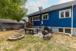 Back of property featuring a lawn, a patio, and an outdoor fire pit