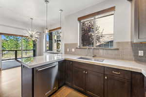 Kitchen with dishwasher, kitchen peninsula, sink, and a wealth of natural light