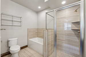 Bathroom featuring shower with separate bathtub, tile patterned floors, and toilet