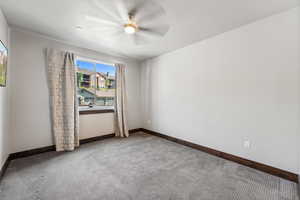 Carpeted empty room with ceiling fan