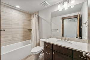 Full bathroom with vanity, toilet, hardwood / wood-style flooring, and shower / bath combo