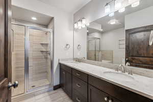 Bathroom featuring tile patterned floors, an enclosed shower, vanity, and toilet