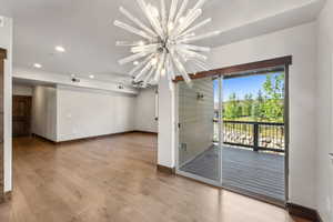 Interior space featuring an inviting chandelier, light hardwood / wood-style flooring, and plenty of natural light