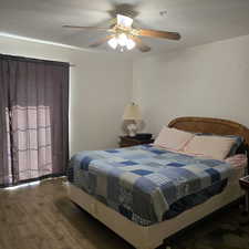 Bedroom featuring a textured ceiling, dark hardwood / wood-style flooring, and ceiling fan