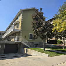 View of front facade featuring a balcony, a garage, and a front yard