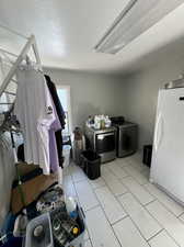 Washroom with a textured ceiling and washer and dryer