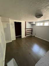 Interior space with a textured ceiling and dark hardwood / wood-style flooring