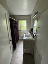 Bathroom featuring vanity, tile patterned flooring, and a textured ceiling