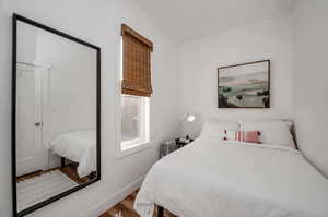 Bedroom with radiator and hardwood / wood-style flooring