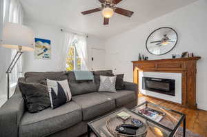 Living room with light hardwood / wood-style floors and ceiling fan