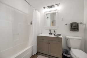 Full bathroom featuring shower / bath combo with shower curtain, vanity, and toilet