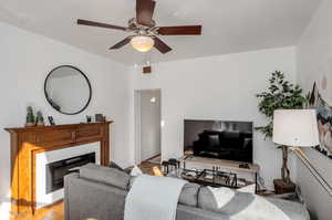 Living room with ceiling fan and light hardwood / wood-style flooring