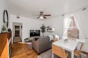 Living room featuring wood-type flooring and ceiling fan