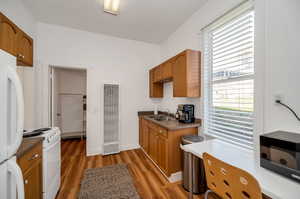 Kitchen with white appliances, dark hardwood / wood-style floors, sink, and plenty of natural light