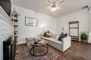 Living room featuring ceiling fan and dark hardwood / wood-style flooring