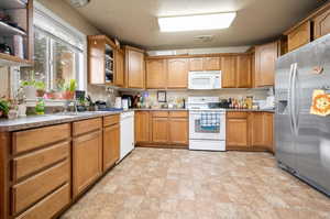 Kitchen with sink and white dishwasher, range and stainless steel fridge