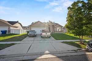 View of front of house with a garage and a front lawn