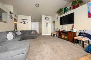 Living room with vaulted ceiling and carpet flooring