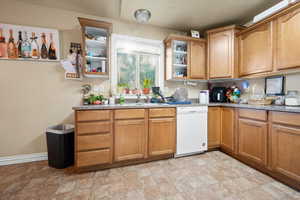 Kitchen with dishwasher, sink, and light counters