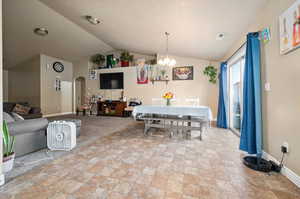 Dining space featuring vaulted ceiling and an inviting chandelier