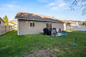 Back of house featuring a mountain view, a yard, and a patio area