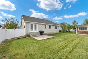 Back of house featuring a lawn and a patio